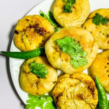 Baked Lentil Hand Pies arranged with green chilies and cilantro