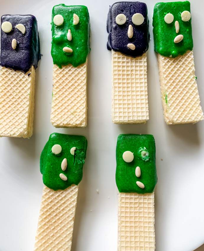 Green and Purple Halloween Wafer Cookies arranged on white plate