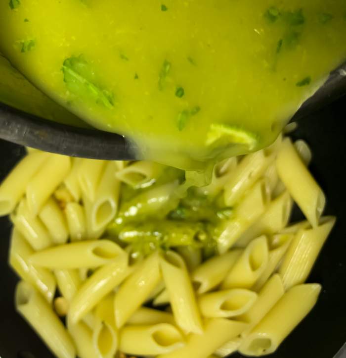 Pouring Lemon Basil Pesto Sauce on the Pasta