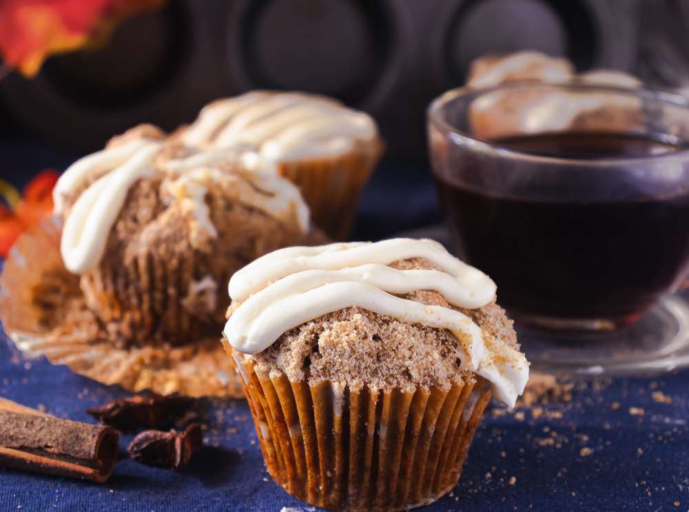Cinnamon Streusel Pumpkin Muffins with cinnamon stick and tea in the back