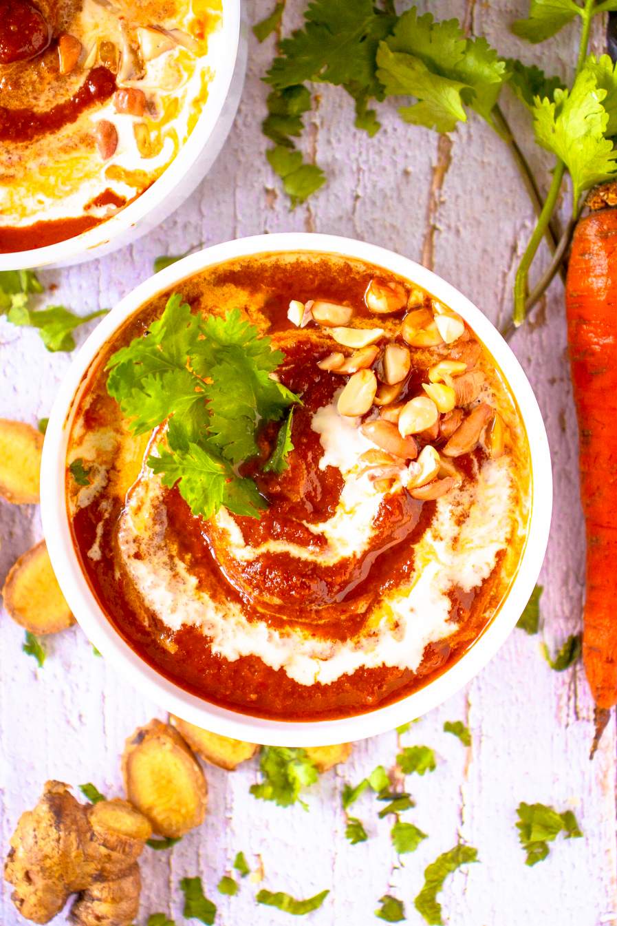 Thai curried roasted carrot and ginger soup on a white background