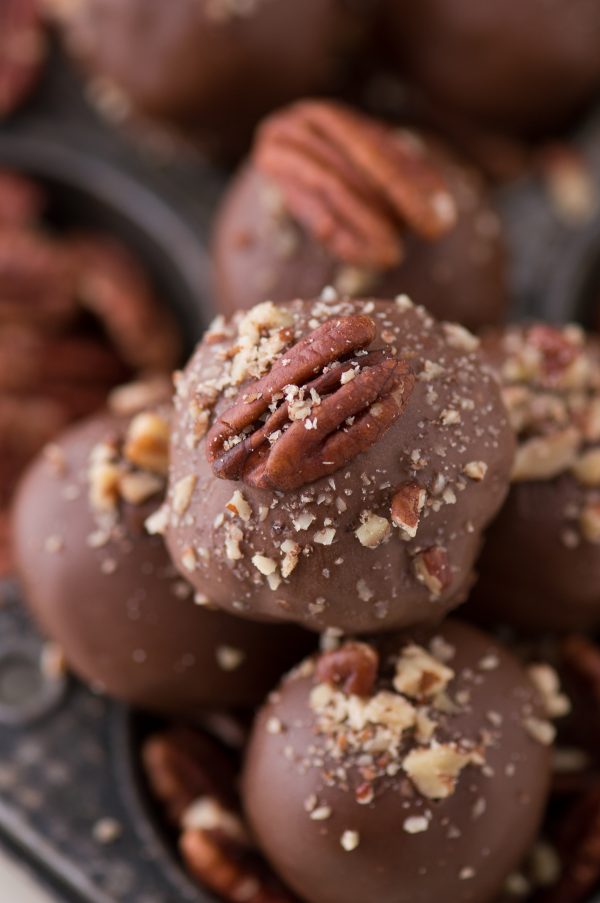 Oreo balls covered in dark chocolate and topped with pecan nut