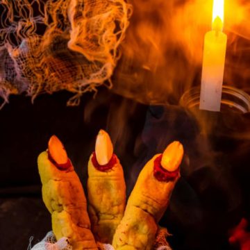 Witchs fingers sugar cookies with candle and bandage in the background