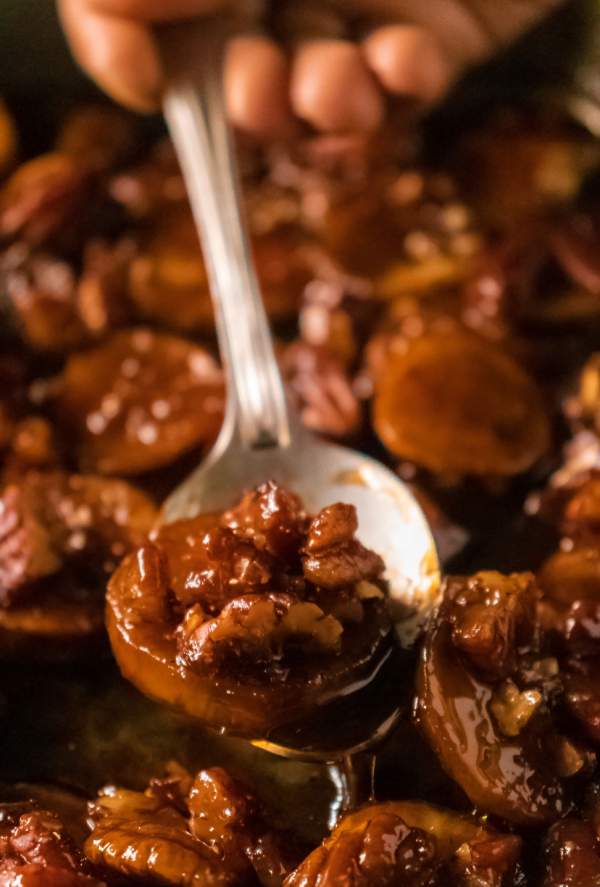 A spoon of Candied Sweet Potatoes with Pecan Topping