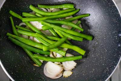 sauteeing green beans over butter with shallots and garlic