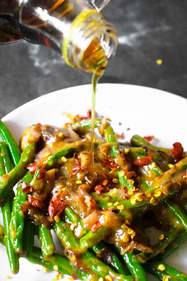 Drizzling Maple syrup over Maple Mustard Glazed Green Beans 