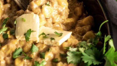 Picking out a spoon of creamed corn from a black utensil