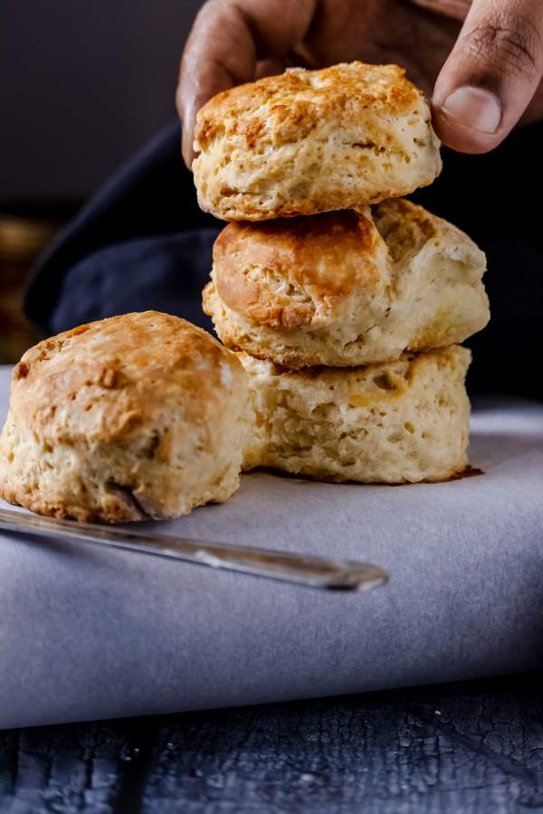 Biscuits on top of each other with one hand keeping the top one 