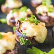 Cream Cheese Stuffed Mushrooms kept on a black table with many others blurred in the background