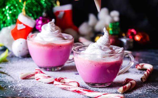 Creamy Peppermint White Hot Chocolate with Coconut Milk with frosting and candy canes on side