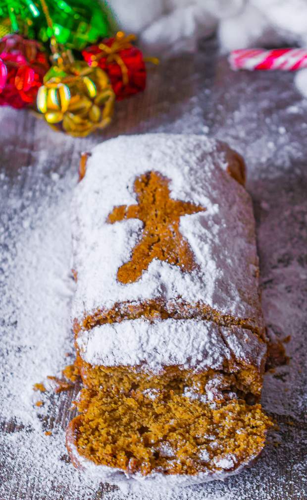 Moist homemade gingerbread loaf cake with powdered sugar on top and loaves cut out