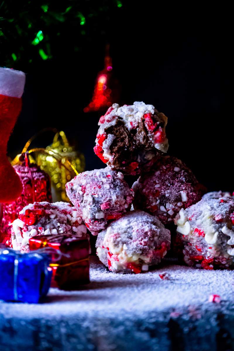 Peppermint Cheesecake Oreo Truffles arranged in stack with the top one eaten in half