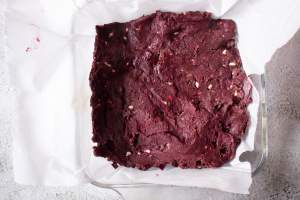 red velvet brownie batter spread out in a baking dish