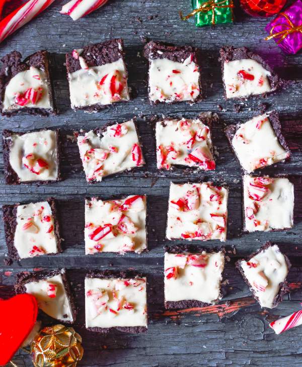 White Chocolate Peppermint Brownies laid out on a table with christmas ornaments around it