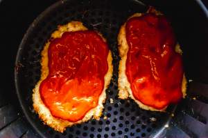 mozzarella cheese on chicken breasts kept in an air fryer