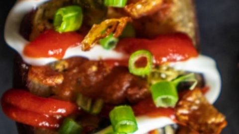 Sweet Potato skins placed in a black plate with garnish on top