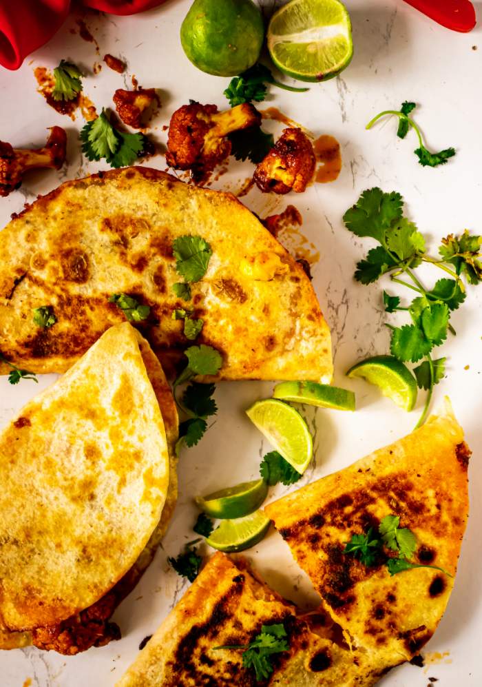Crispy Cauliflower Tinga Tacos with lemon wedges around