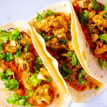 Crispy Roasted Cauliflower Tacos with Chipotle Romesco on a white table