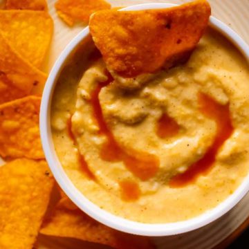 Nacho Cheese Sauce with tortilla chips dipping in