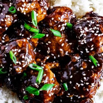sesame chicken with spring onions on white rice
