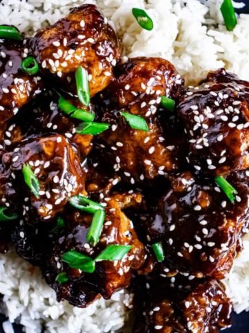 sesame chicken with spring onions on white rice