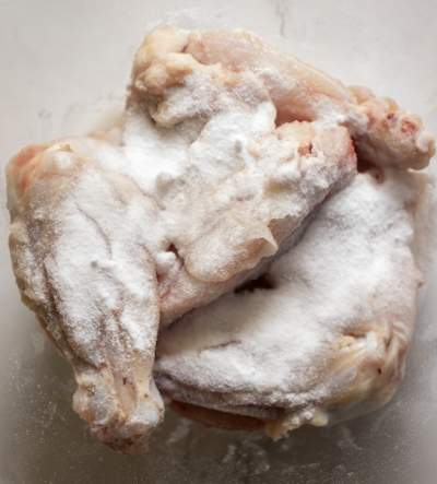 coating chicken with flour and salt for Baked Buffalo Wings