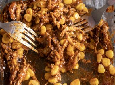 shredding chicken with corn for Honey Chipotle Chicken Tacos