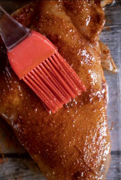 brushing chicken breast with seasoning