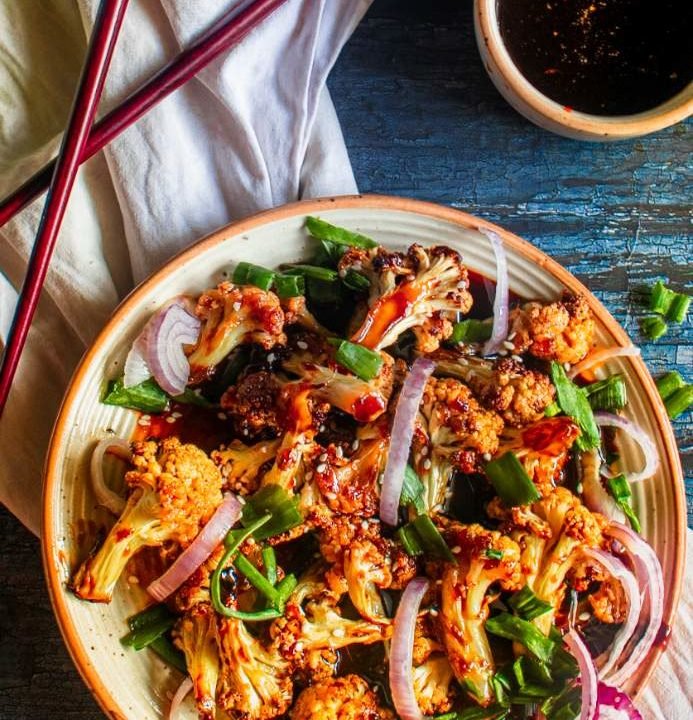 Overhead shot of Korean Cauliflower Wings with chopsticks and gochujang sauce
