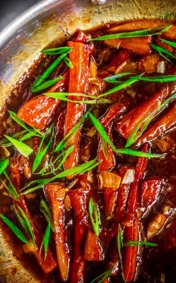 miso glazed carrots with spring onions in a saute pan