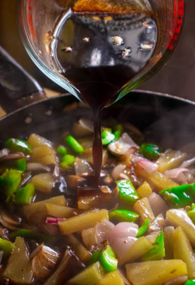 pouring Sweet and Sour sauce over the veggies