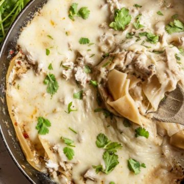 white chicken skillet lasagna in a skillet with spatula