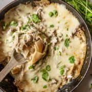 white chicken skillet lasagna in a skillet with spatula in it
