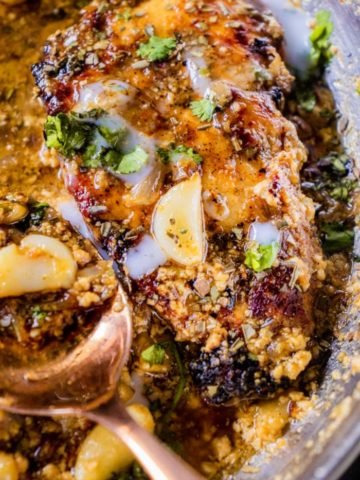 spoon of garlic butter sauce and chicken breast