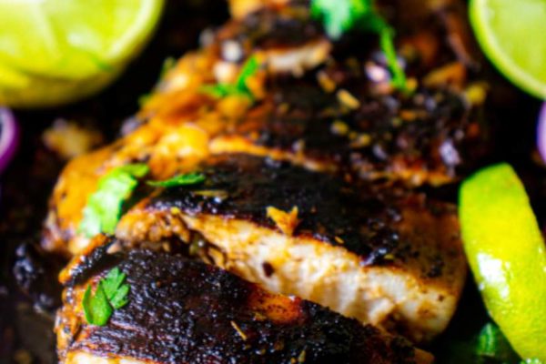 balsamic marinated chicken breast with cilantro and lime wedges around