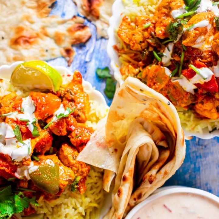 Instant Pot Chicken Tikka Masala in a bowl with naan bread and raita beside