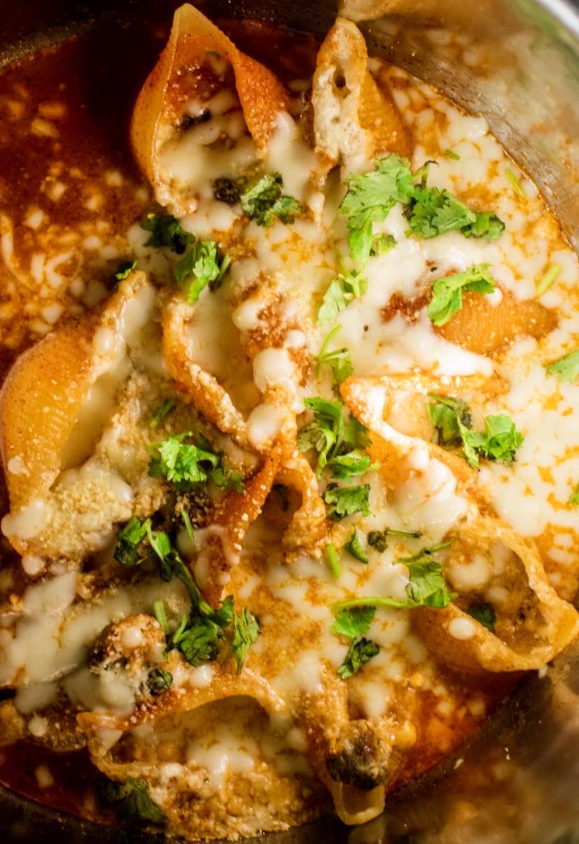 stuffed shells in instant pot with cheese and chopped parsley on top