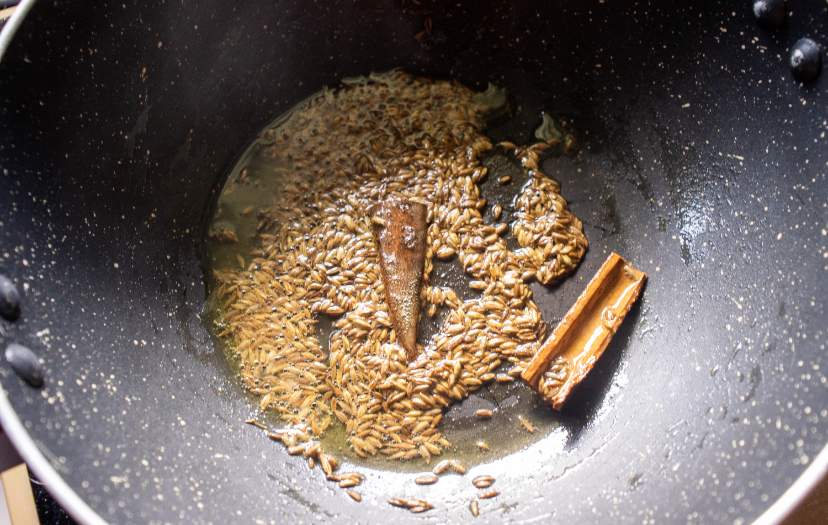 sauteing jeera and dalchini in a pot