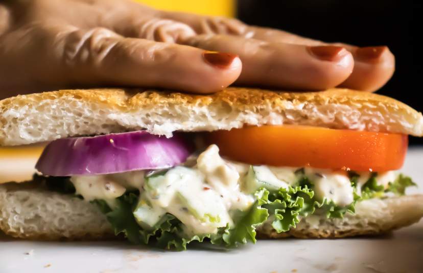 assembling salmon salad sandwich on a sandwich bread