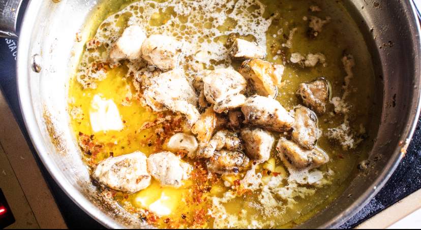 cooked cubes of chicken added to the skillet