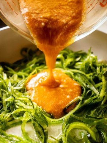 Pouring Bang bang Sauce on Zucchini Noodles