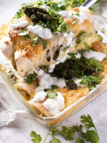 picking out chicken enchiladas with a slotted spoon