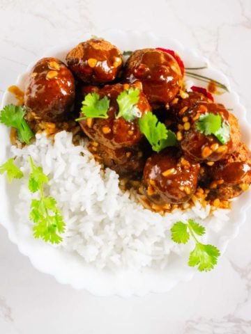 thai meatballs with peanut sauce in a plate with rice