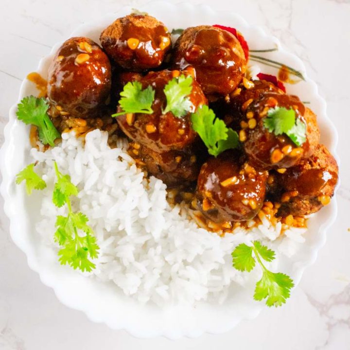 thai meatballs with peanut sauce in a plate with rice