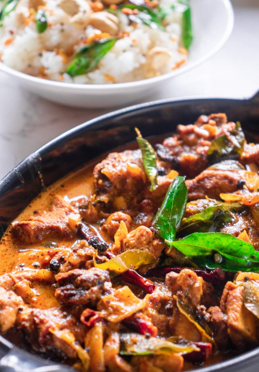 kerala coconut chicken curry with rice in the background