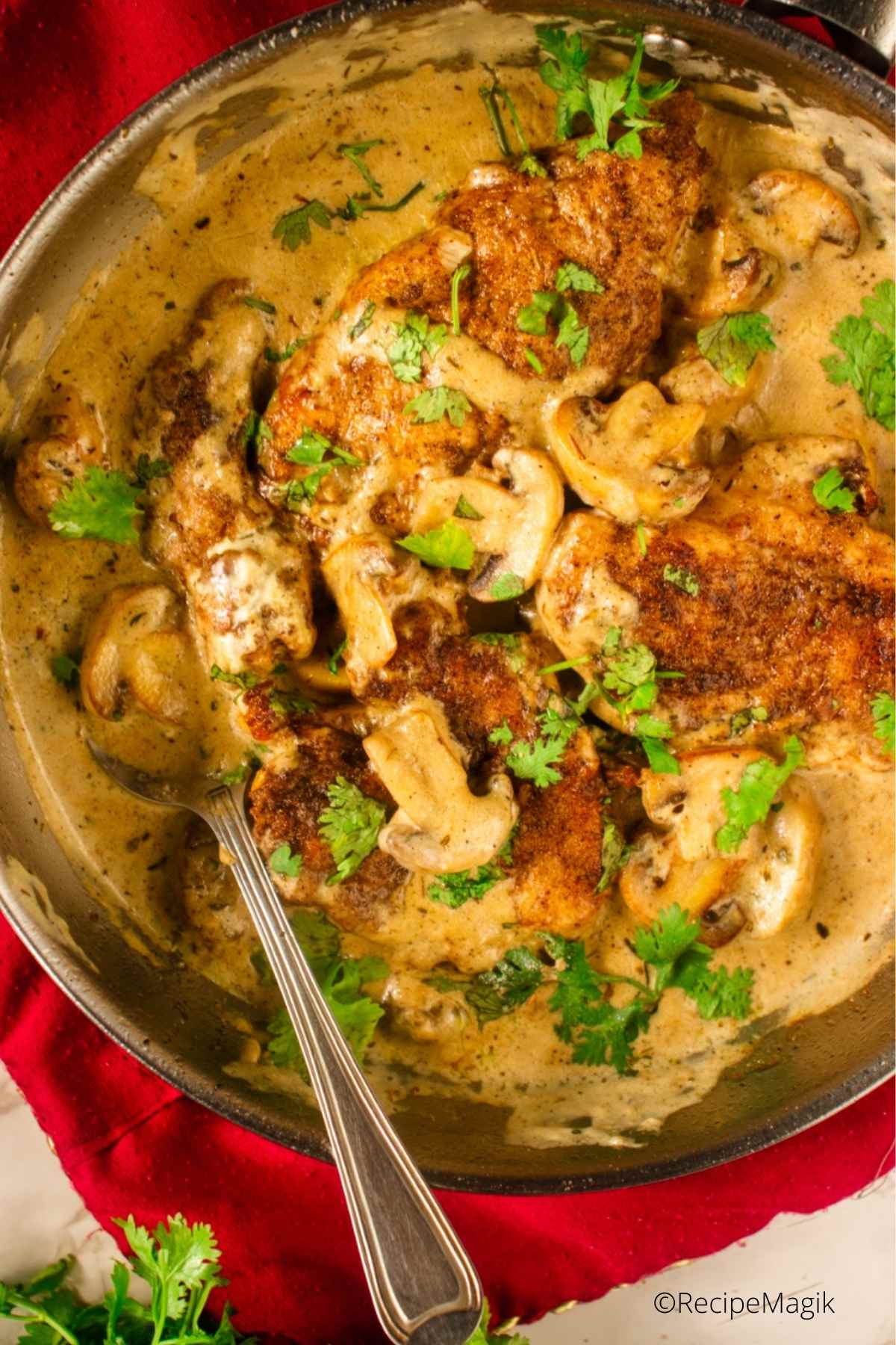 chicken marsala in a skillet with spoon
