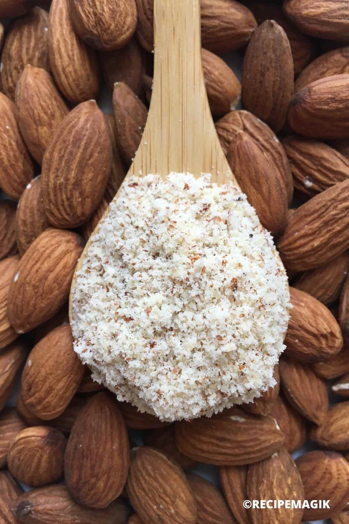almond flour in a spoon with almonds in the background