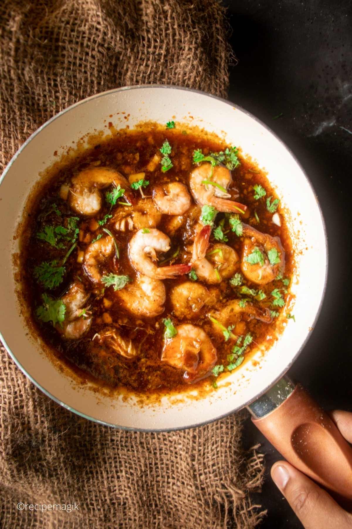 Spicy New Orleans shrimp in a skillet with burlap underneath it