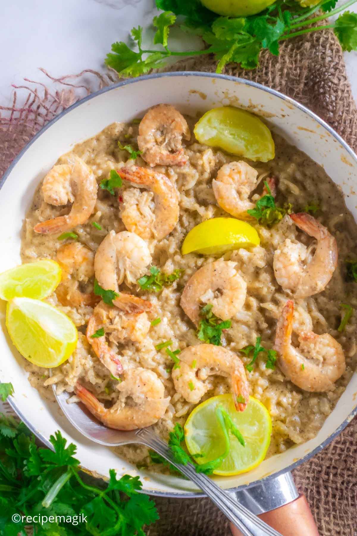 Lemon Butter Shrimp and Rice in a skillet with lemon wedges and parsley with burlap in the background