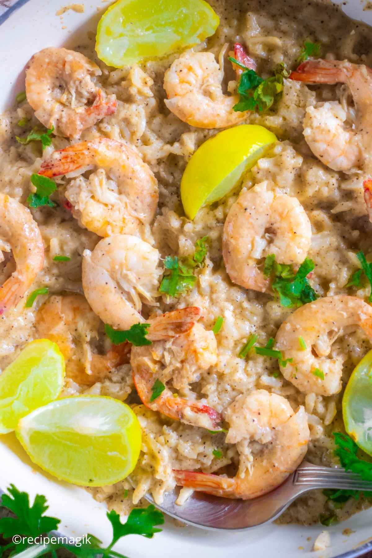 Lemon Butter Shrimp and Rice in a skillet with lemon wedges and parsley